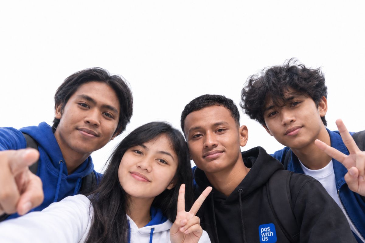 Four members of the Pos With Us team in branded hoodies at the Kerobokan office